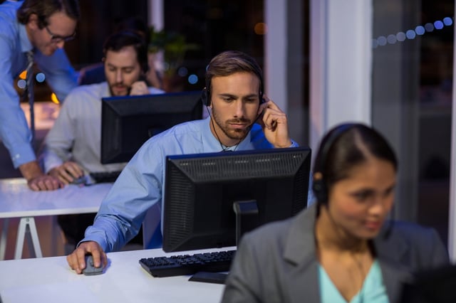 Businessman with headsets using computer in office at night.jpeg